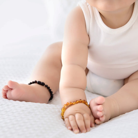 Baby arms and legs with amber braclets on.